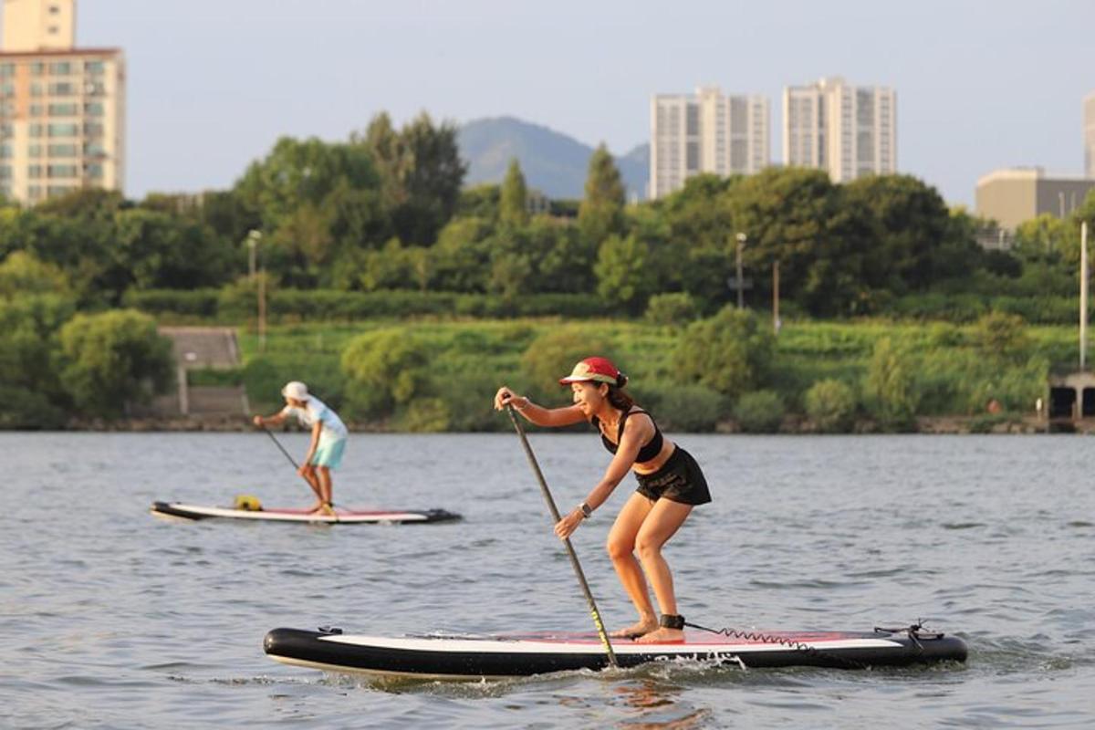 dues persones sobre taules de paddle surf a l'aigua