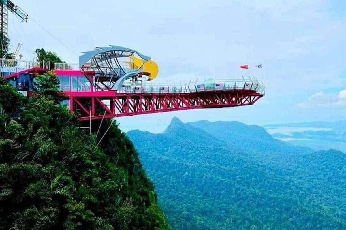 a red suspension bridge on top of a mountain
