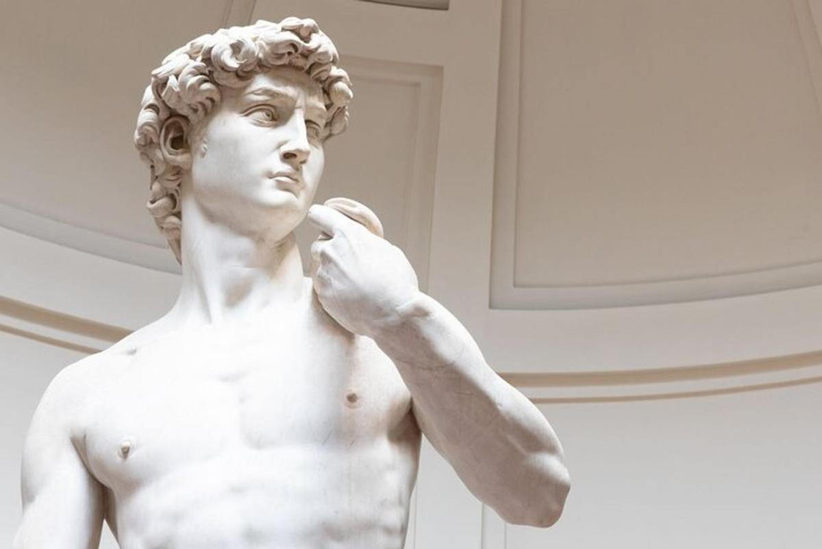 Una estatua de un hombre que se lleva la mano a la oreja.