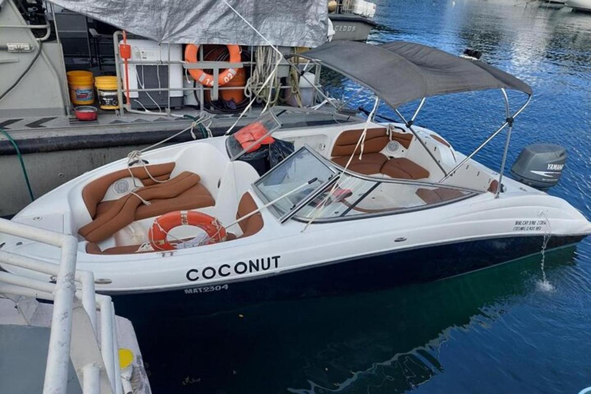 Un barco blanco atado a un muelle con un paraguas.