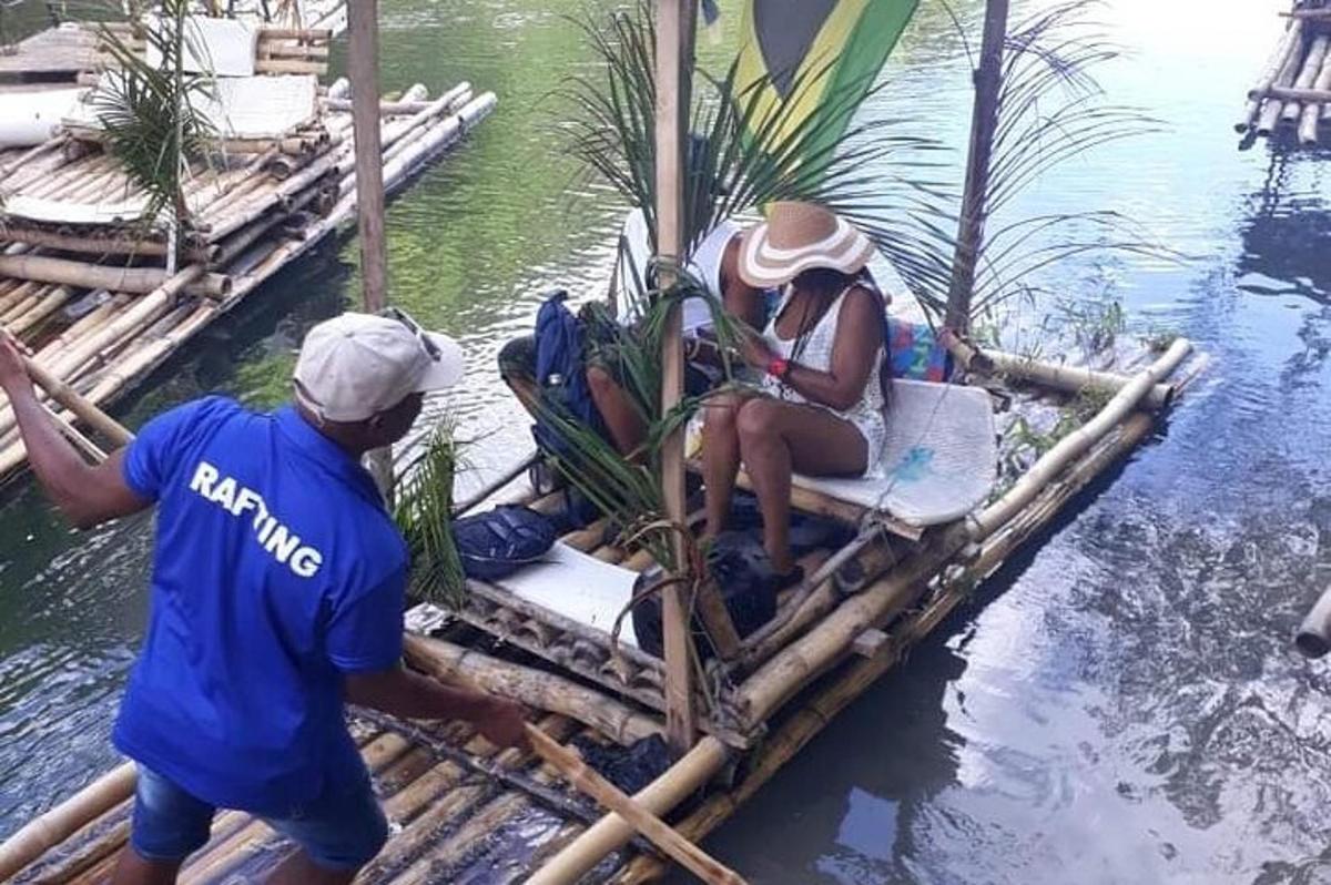dua orang di atas rakit bambu di air