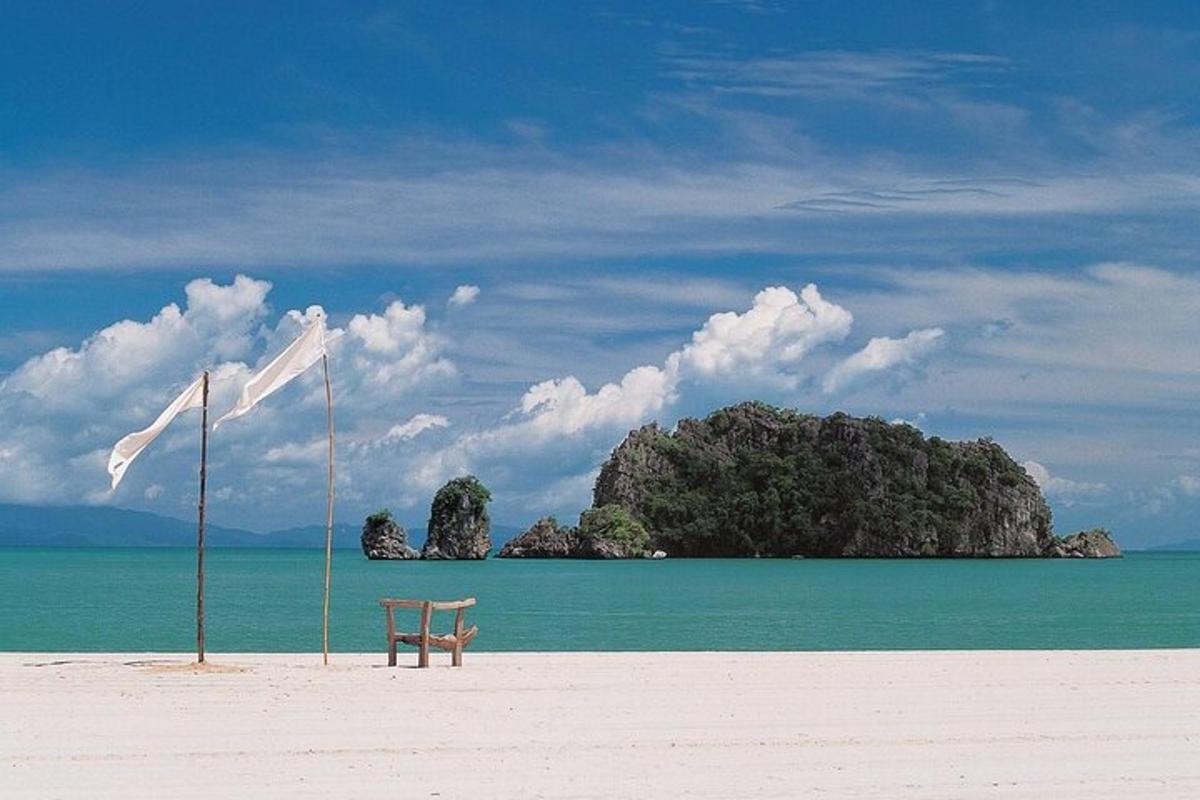 một chiếc ghế trên bãi biển có một hòn đảo trên mặt nước