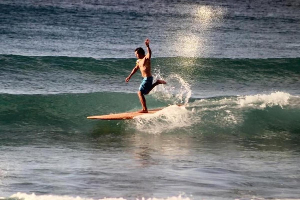 en mand, der rider på en bølge på et surfbræt i havet