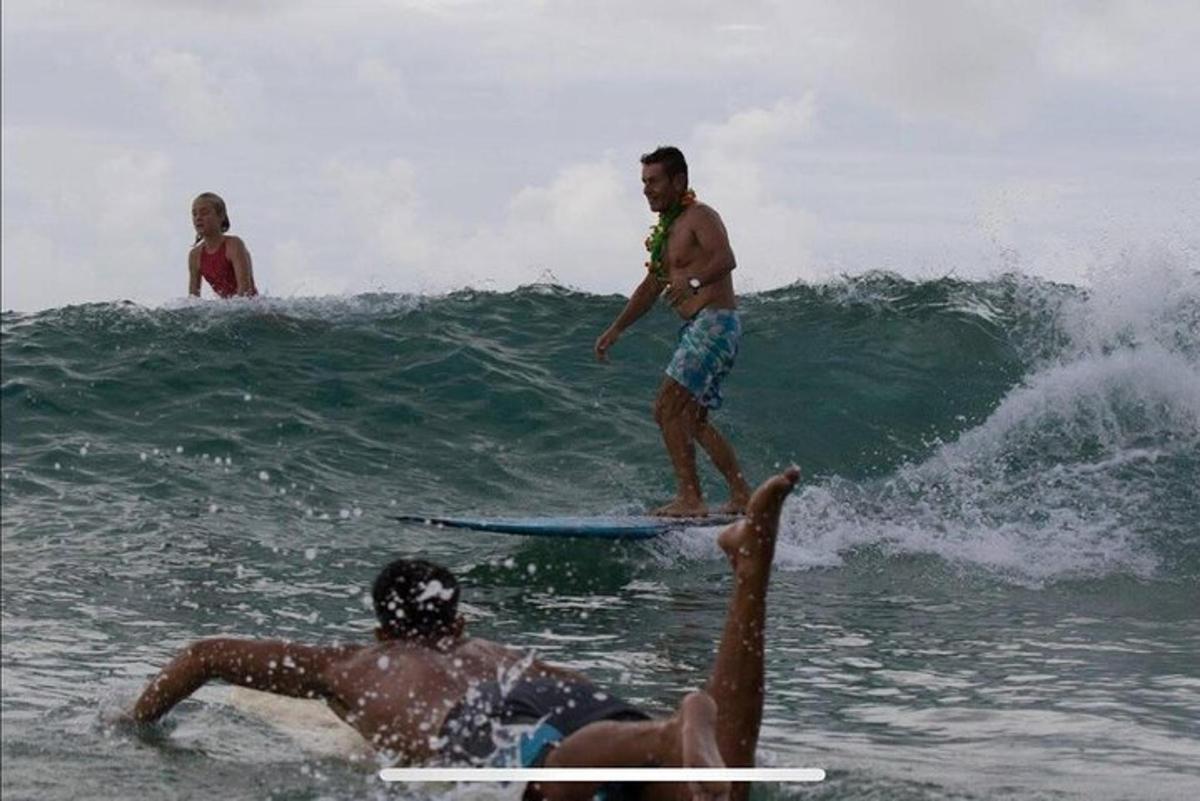 un uomo che cavalca un'onda su una tavola da surf nell'oceano