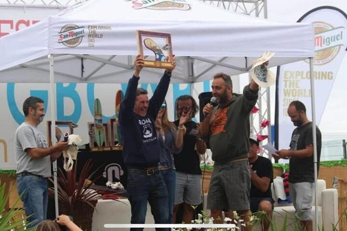 un uomo che solleva un trofeo in aria