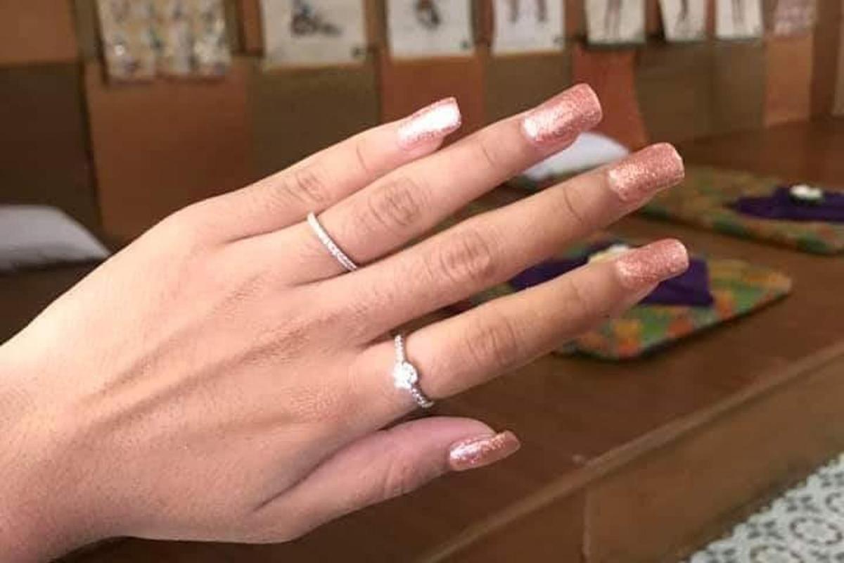 una donna che indossa due anelli alla mano