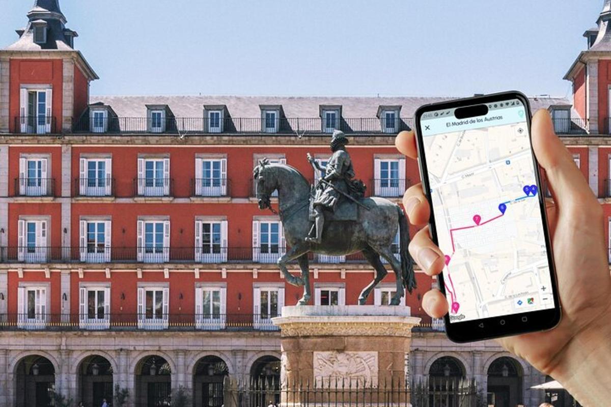 una persona sosteniendo un teléfono celular frente a una estatua