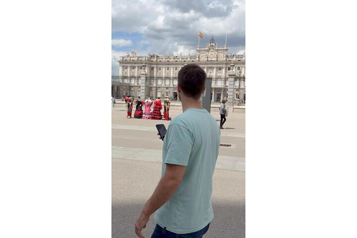 Un hombre de pie frente al palacio de Versalles.