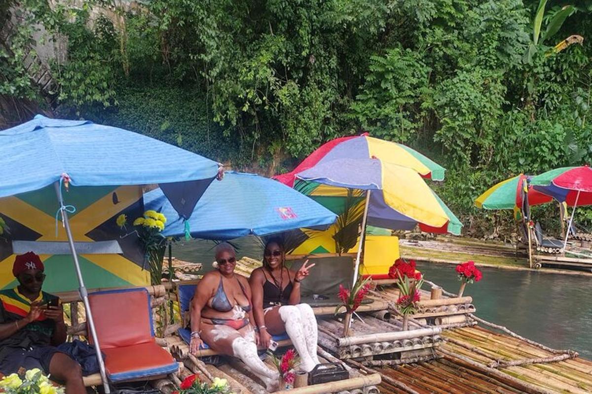 skupina ljudi, ki sedijo pod senčniki na splavu