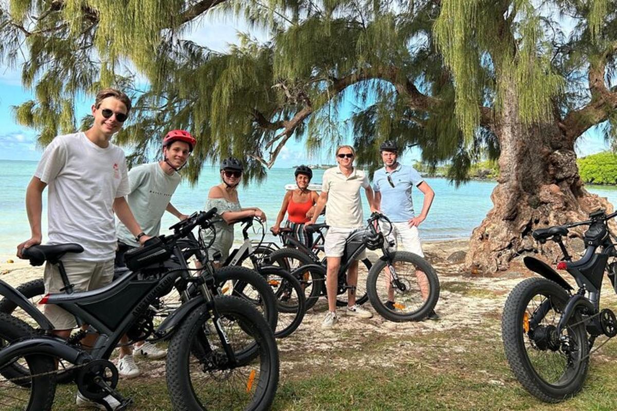 un grup de persones dretes al costat de les seves bicicletes a la platja