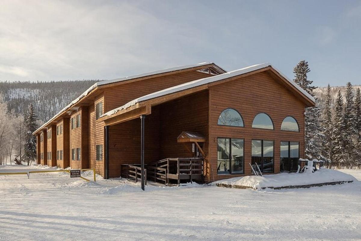 un grande edificio di legno nella neve con alberi