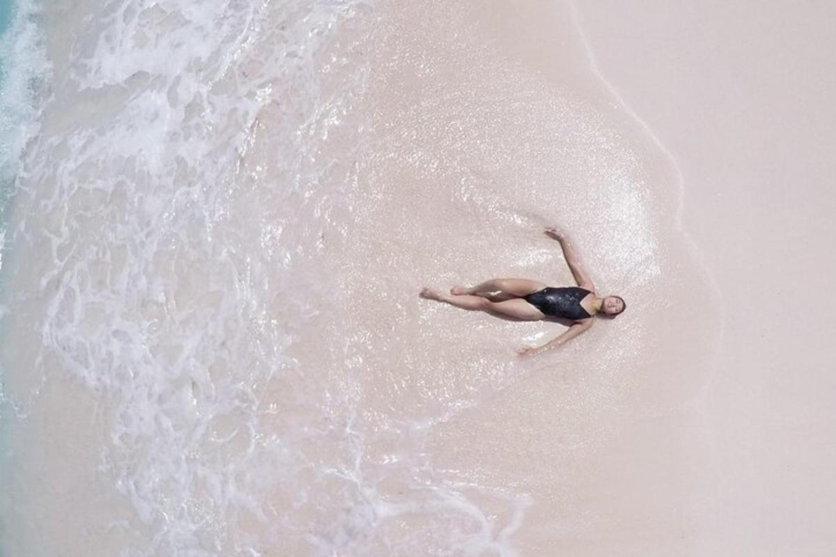 a person laying on the beach near the water