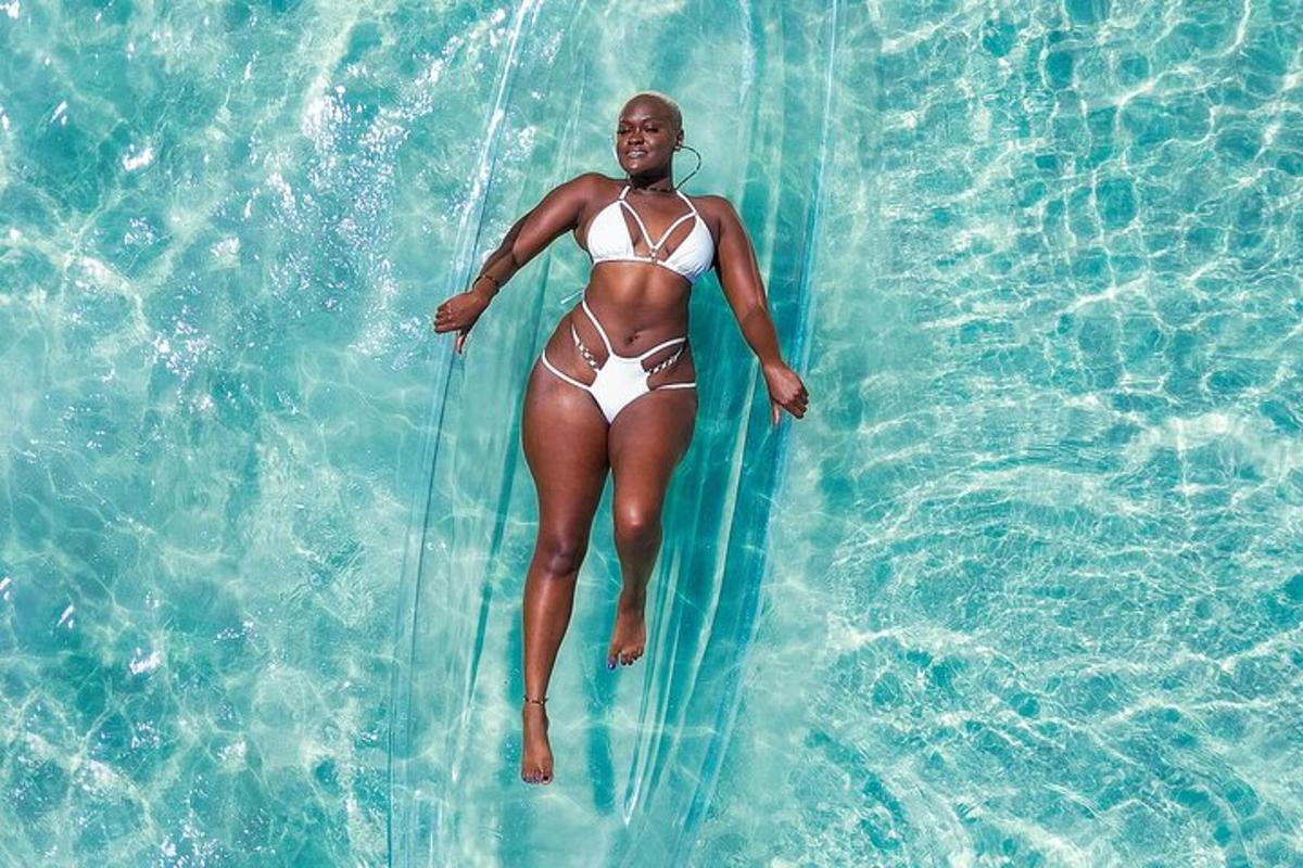 una donna in costume da bagno che cavalca un'onda in una piscina