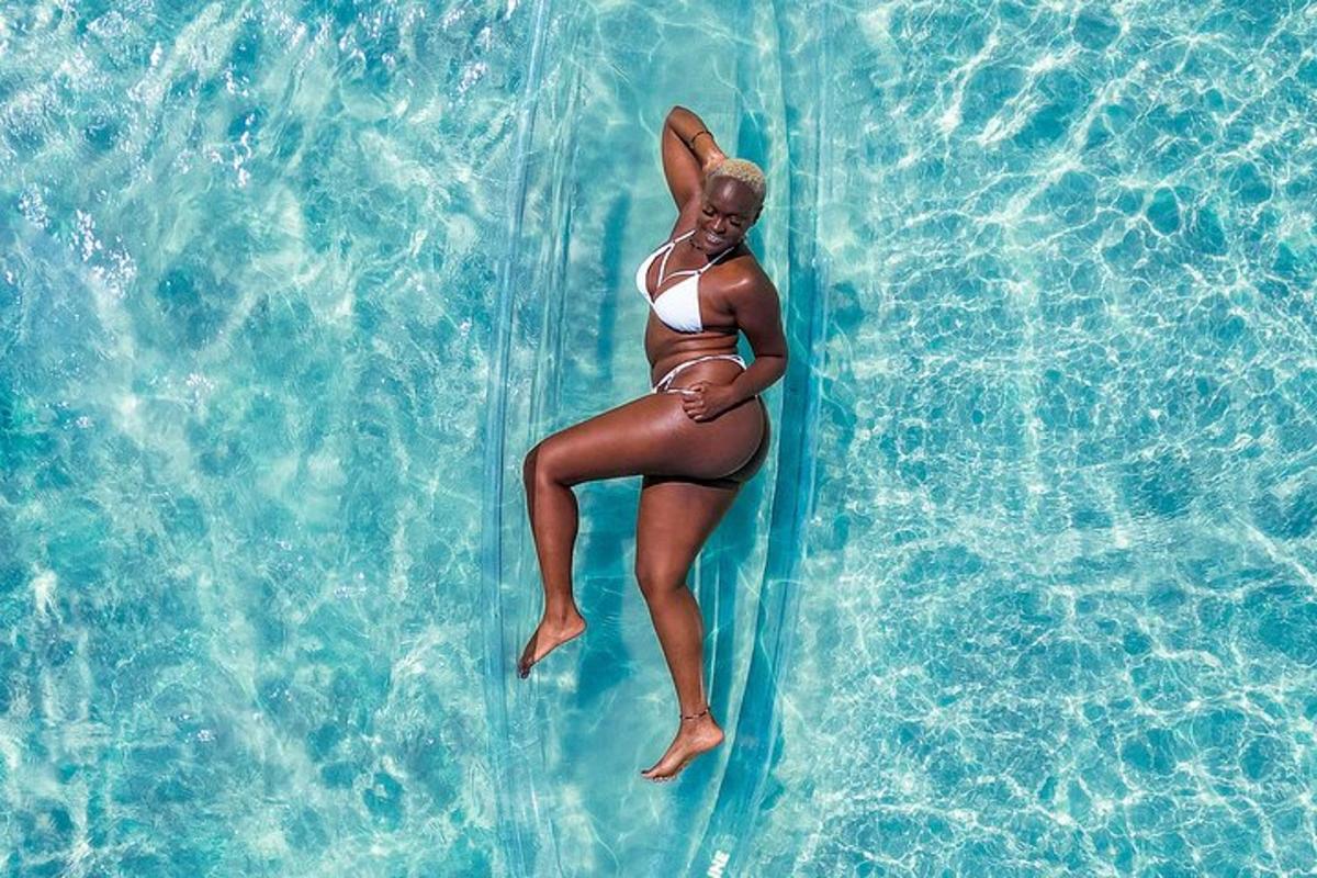 una donna in bikini sdraiata su una zattera in acqua