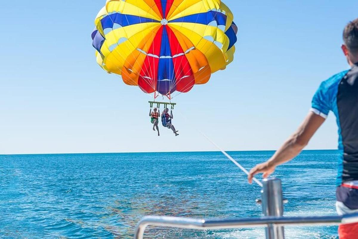 un uomo che fa volare un ombrello colorato sopra l'oceano