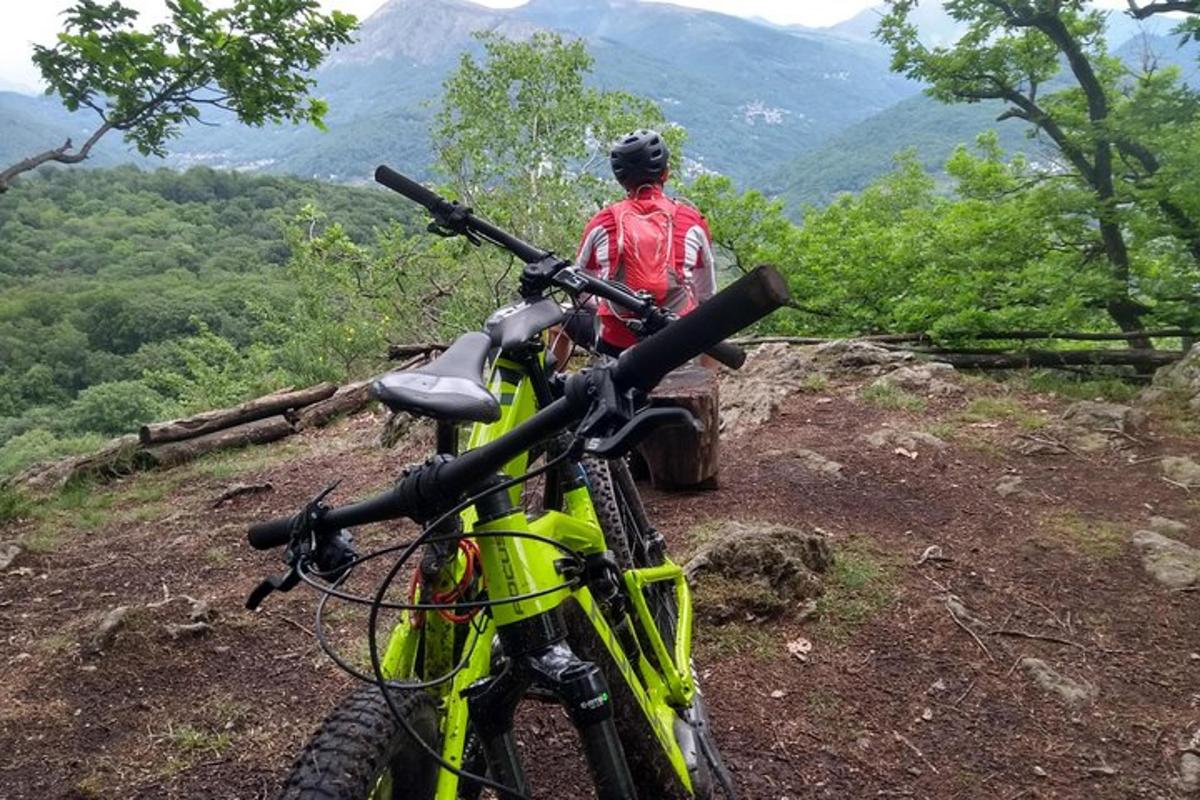 a man standing next to a bike on a hill