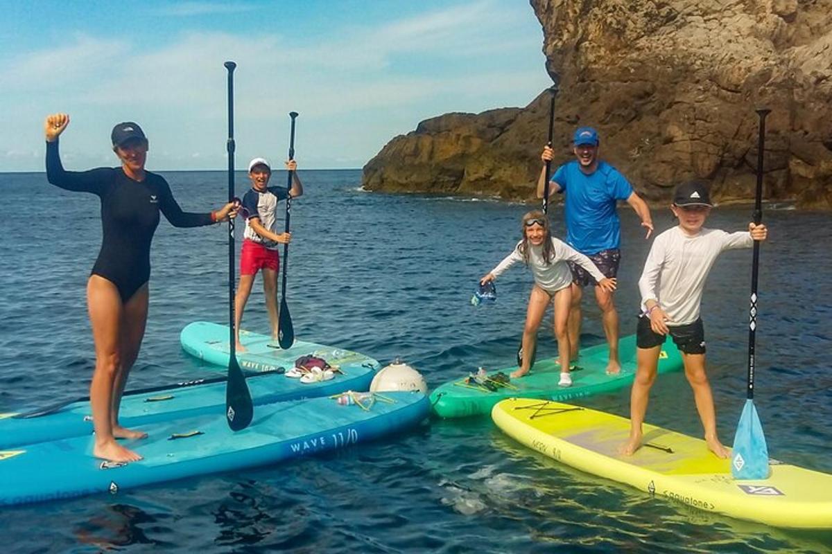 skupina lidí stojících na paddleboardech ve vodě