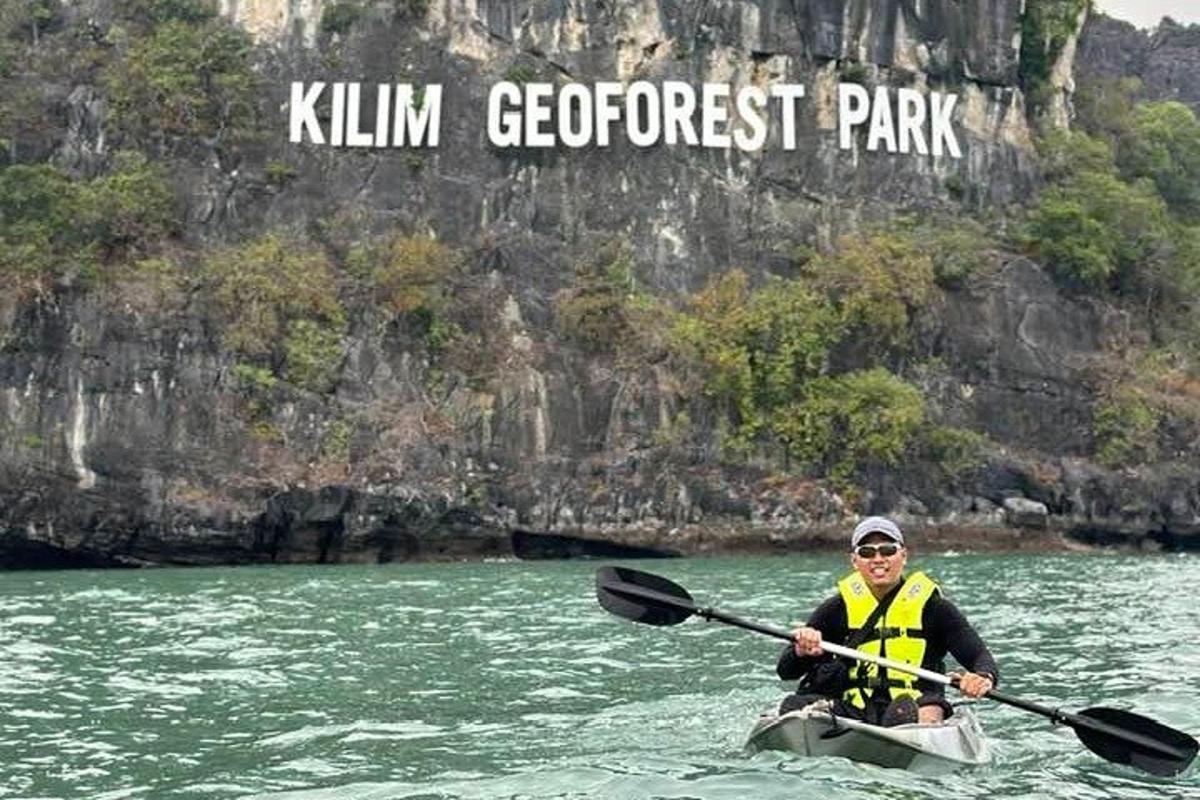 un uomo in kayak in acqua con un cartello
