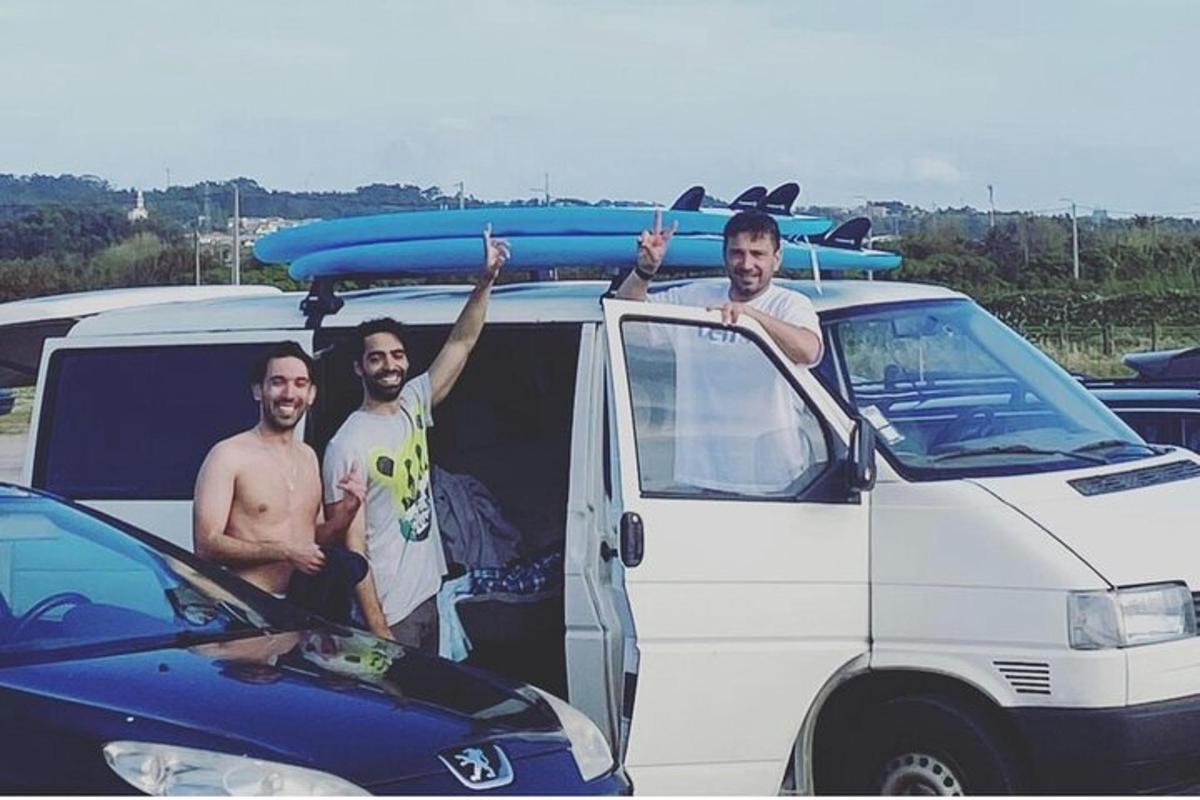 tři muži stojící v zadní části dodávky se surfovacím prknem