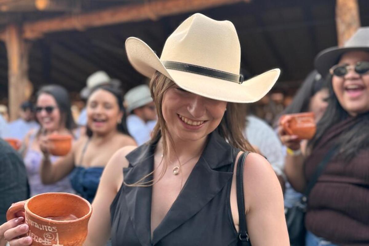 o femeie purtând o pălărie de cowboy ținând o cană