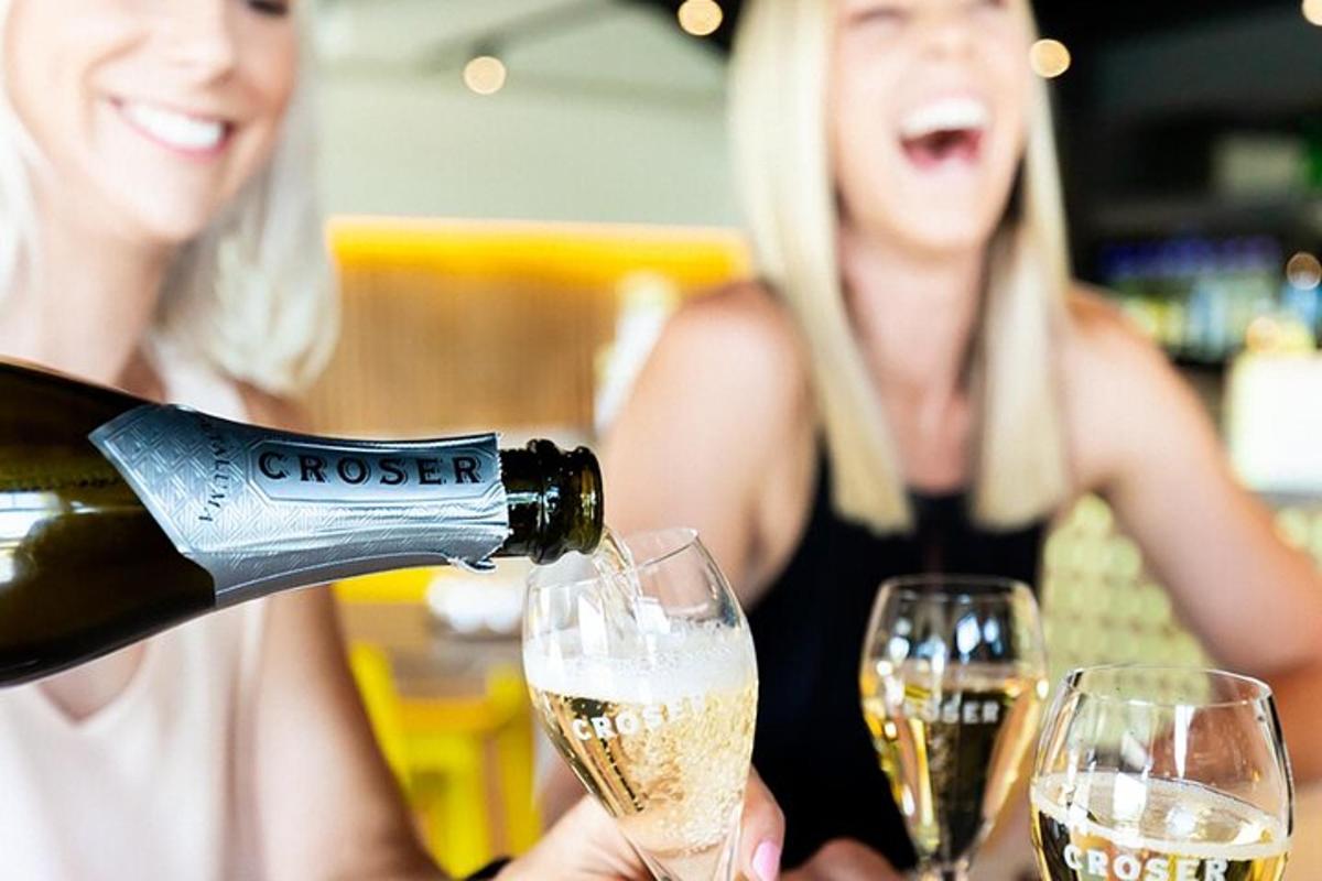dua wanita sedang menuang champagne ke dalam gelas