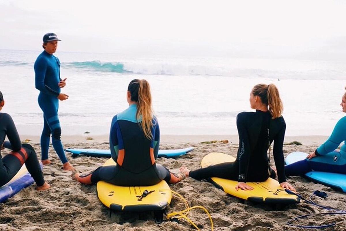 en gruppe mennesker sidder på surfbrætter på stranden