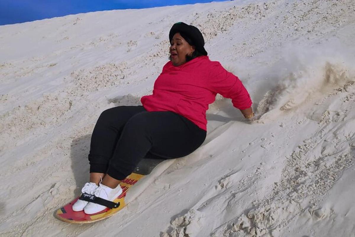 Μια γυναίκα που κάθεται σε ένα snowboard στην άμμο