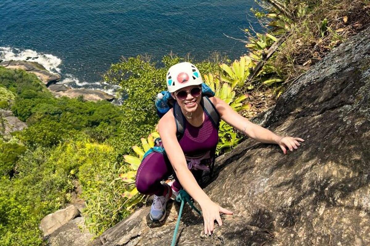 uma mulher sentada em uma rocha perto do oceano