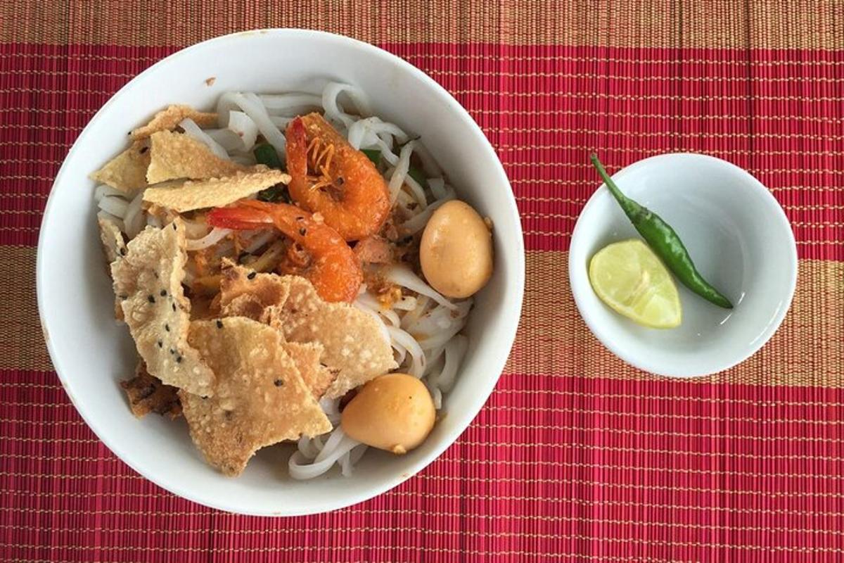 Un tazón de comida con camarones y fideos en una mesa.