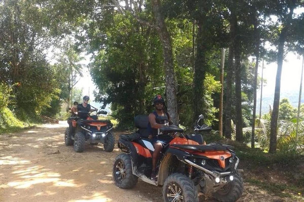 Dos personas conduciendo vehículos todo terreno por un camino de tierra