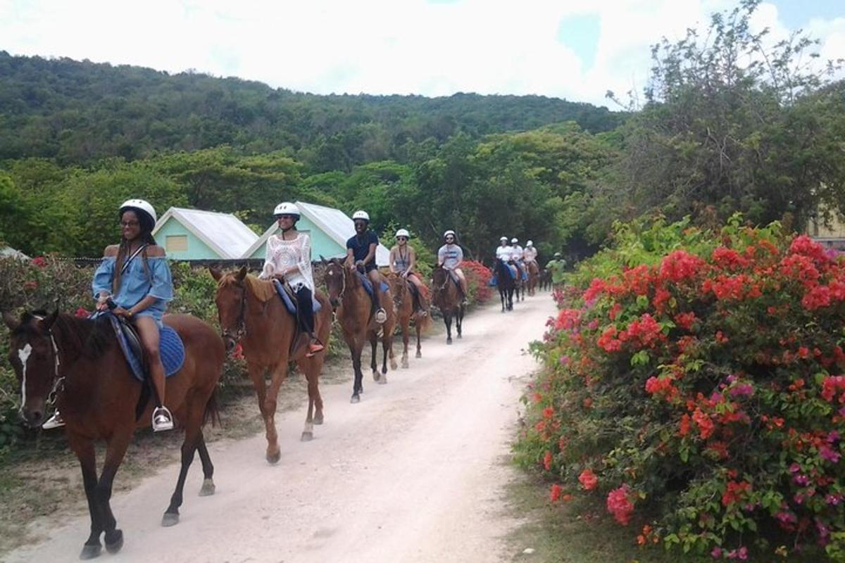 a group of people riding horses down a dirt road