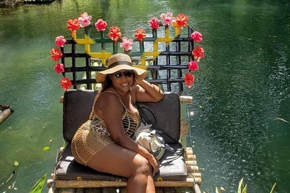 una donna con un cappello di paglia è seduta su una panchina