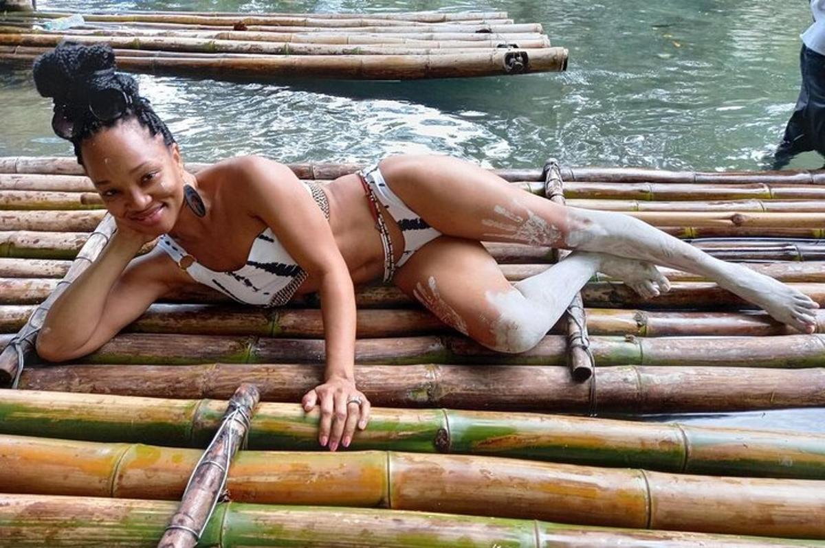 una donna sdraiata su una zattera di bambù nell'acqua