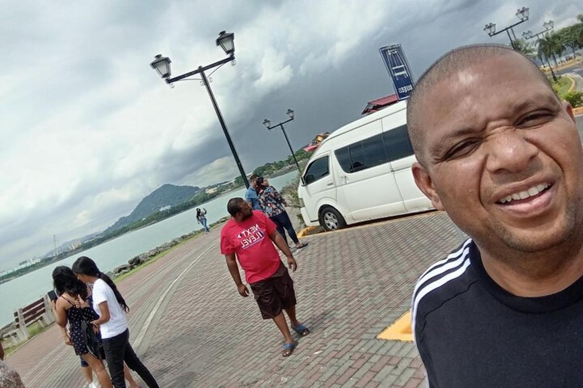un uomo in piedi su un marciapiede vicino all'acqua