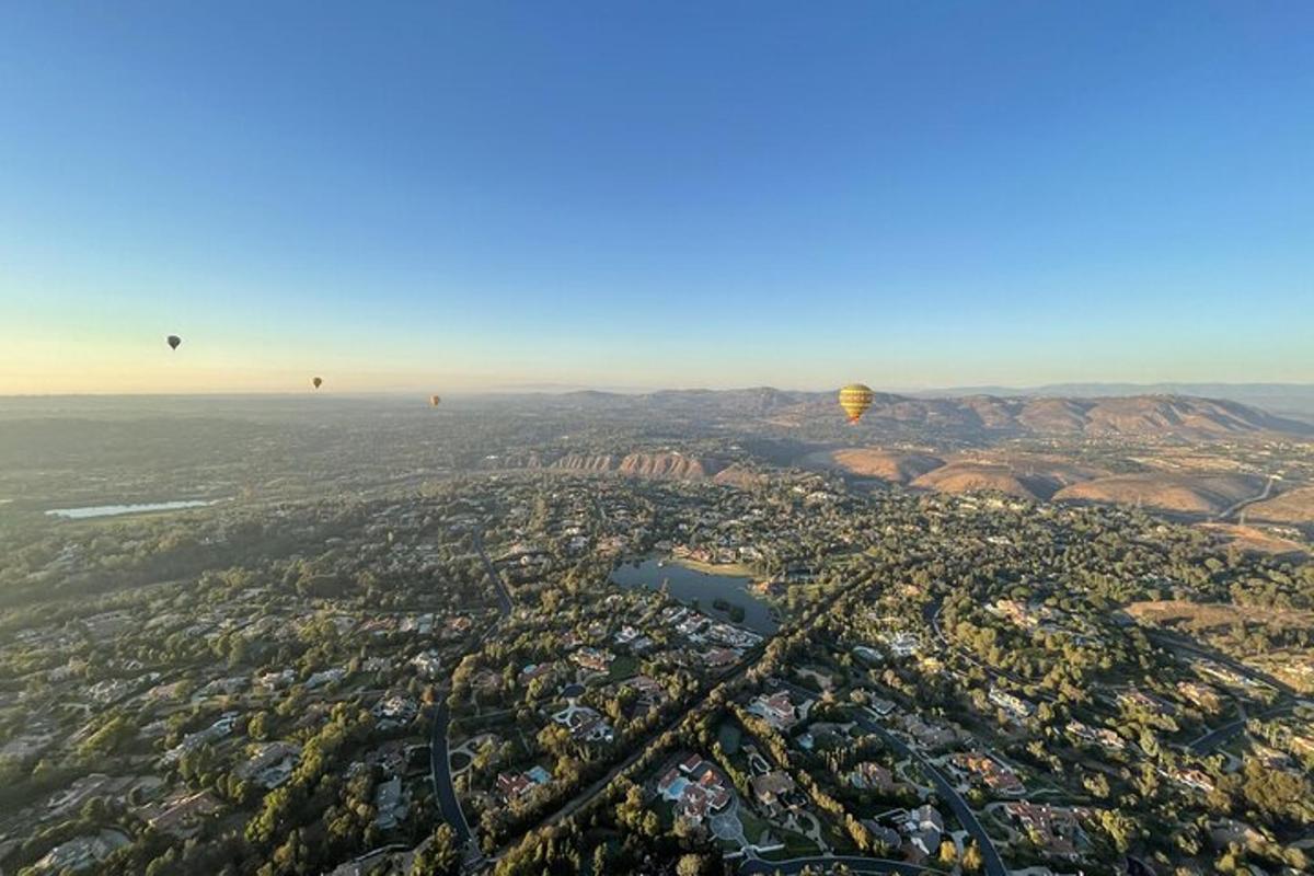 an aerial view of a city with hot air balloons