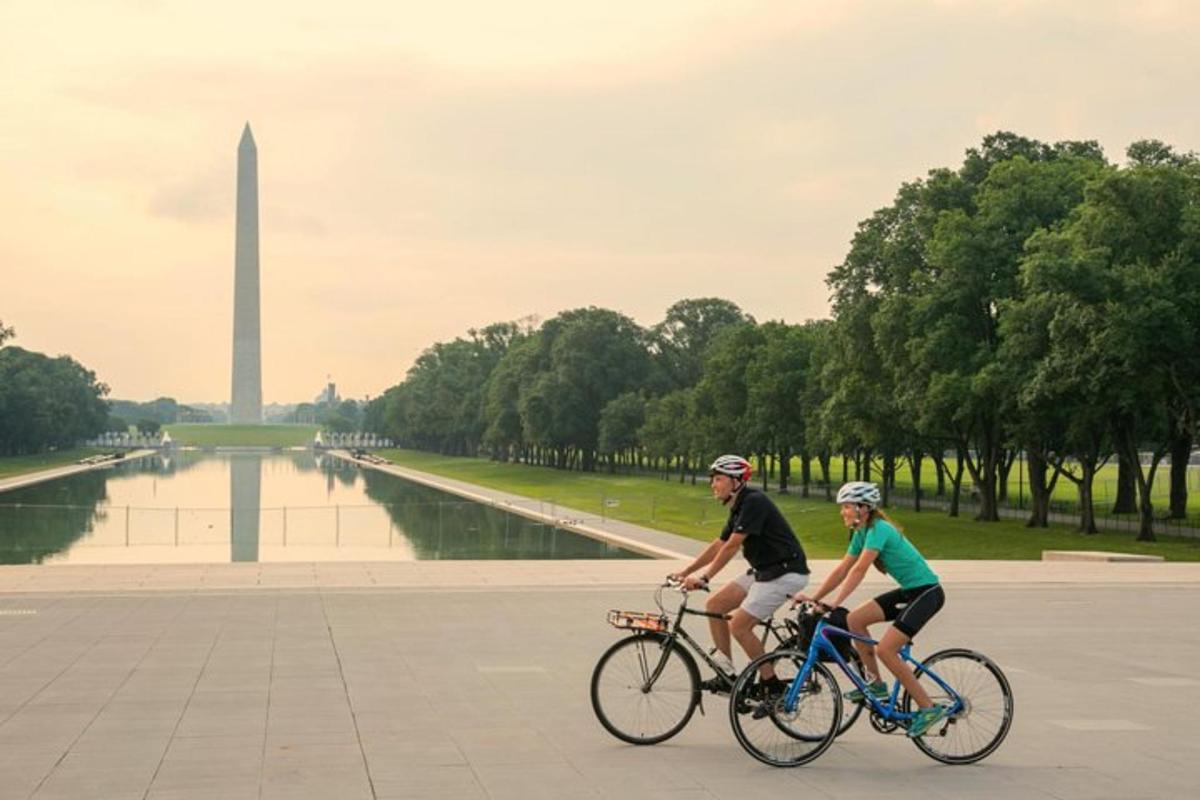 dues persones anant en bicicleta davant del monument a Washington