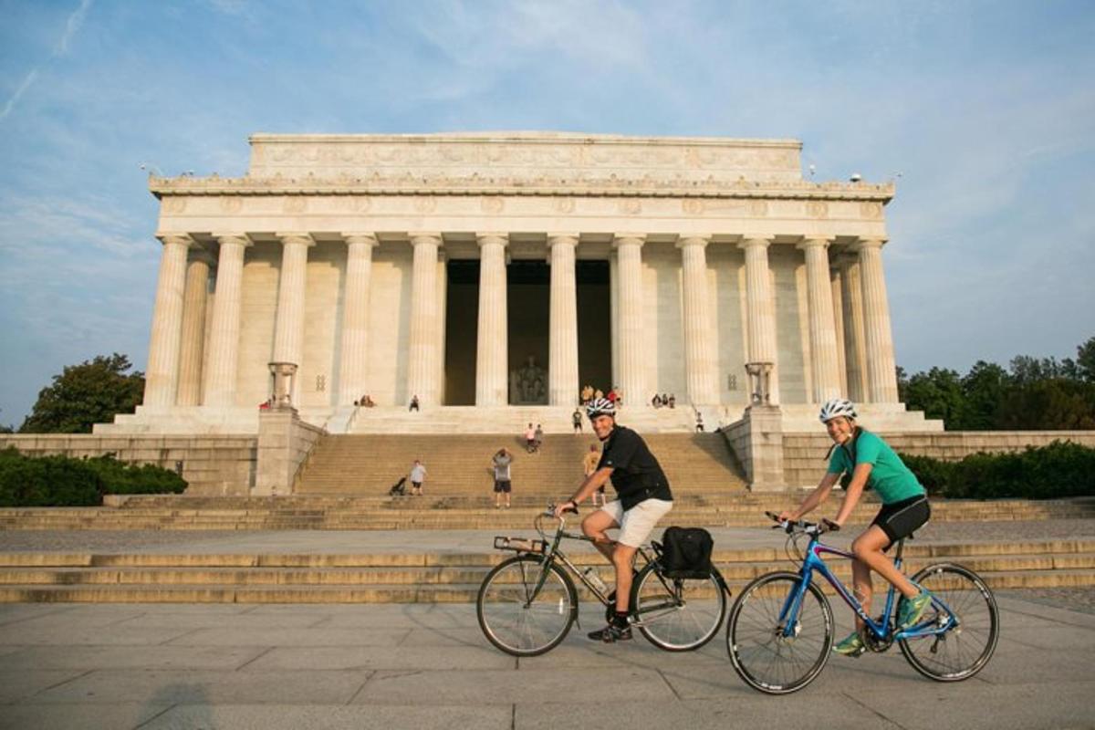 dues persones anant en bicicleta davant d'un edifici