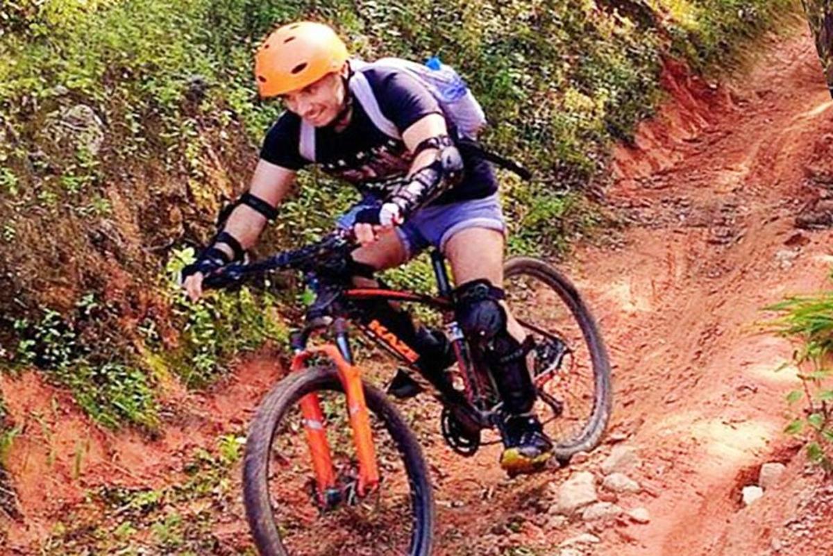 a man riding a bike down a dirt road