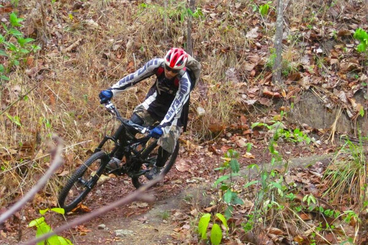 a man riding a bike down a dirt trail