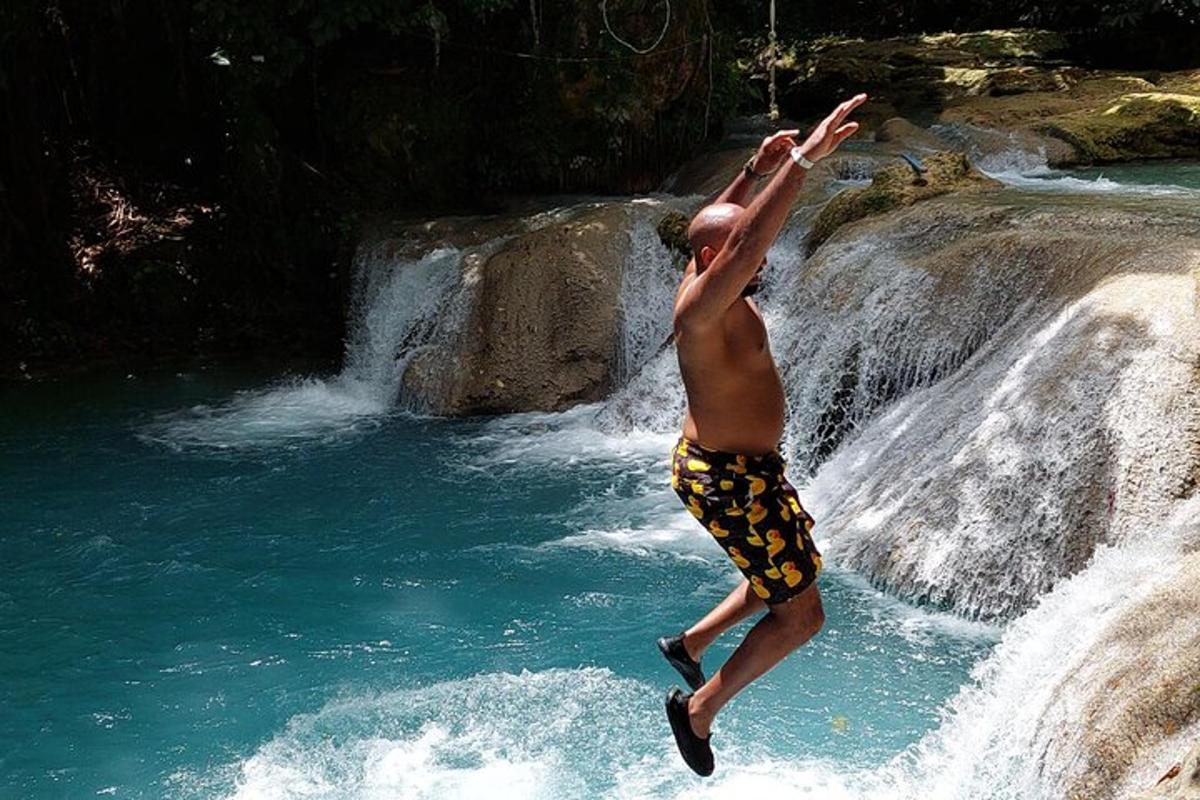 seorang lelaki melompat dari air terjun ke dalam air
