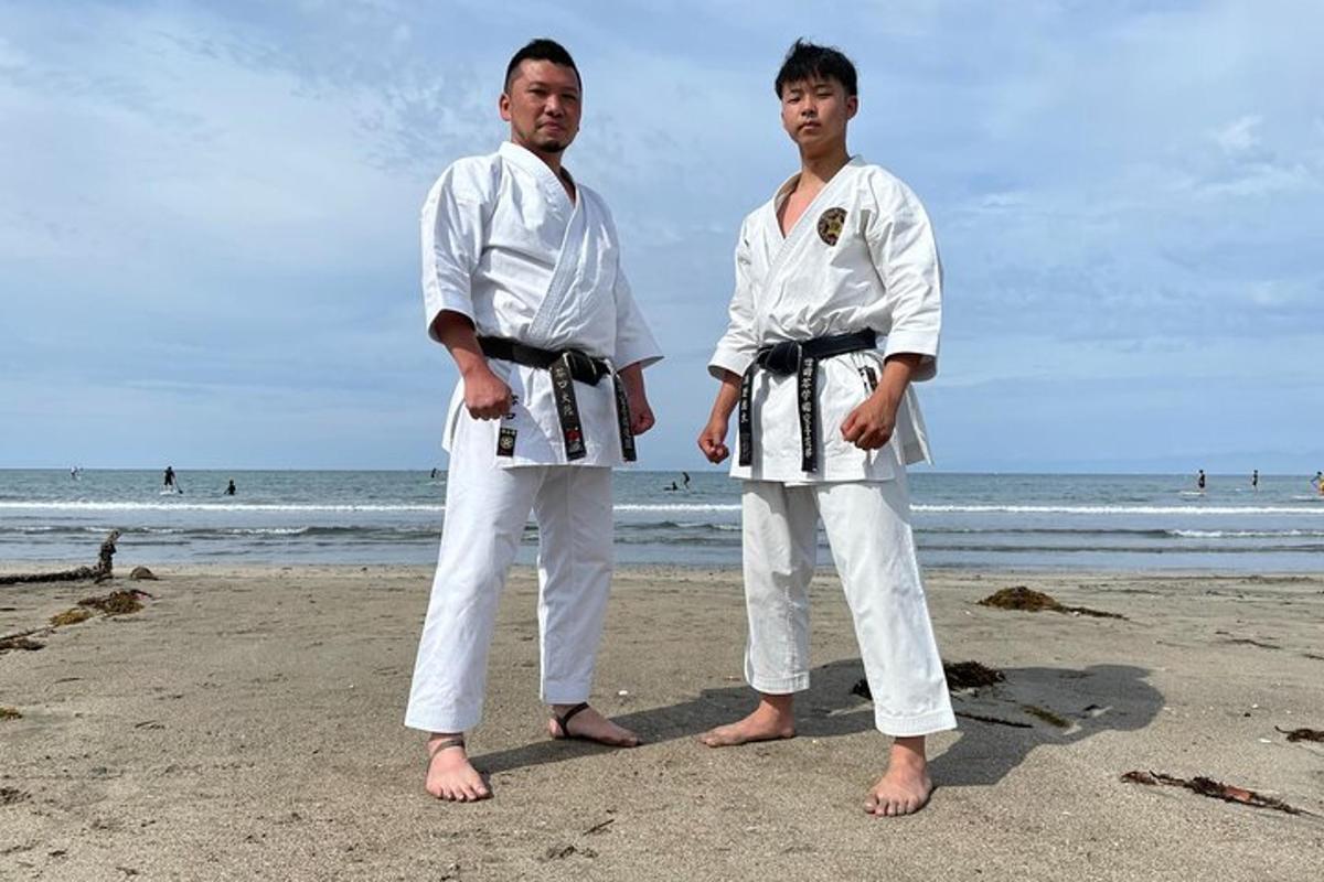 dua pria berkimono putih berdiri di pantai