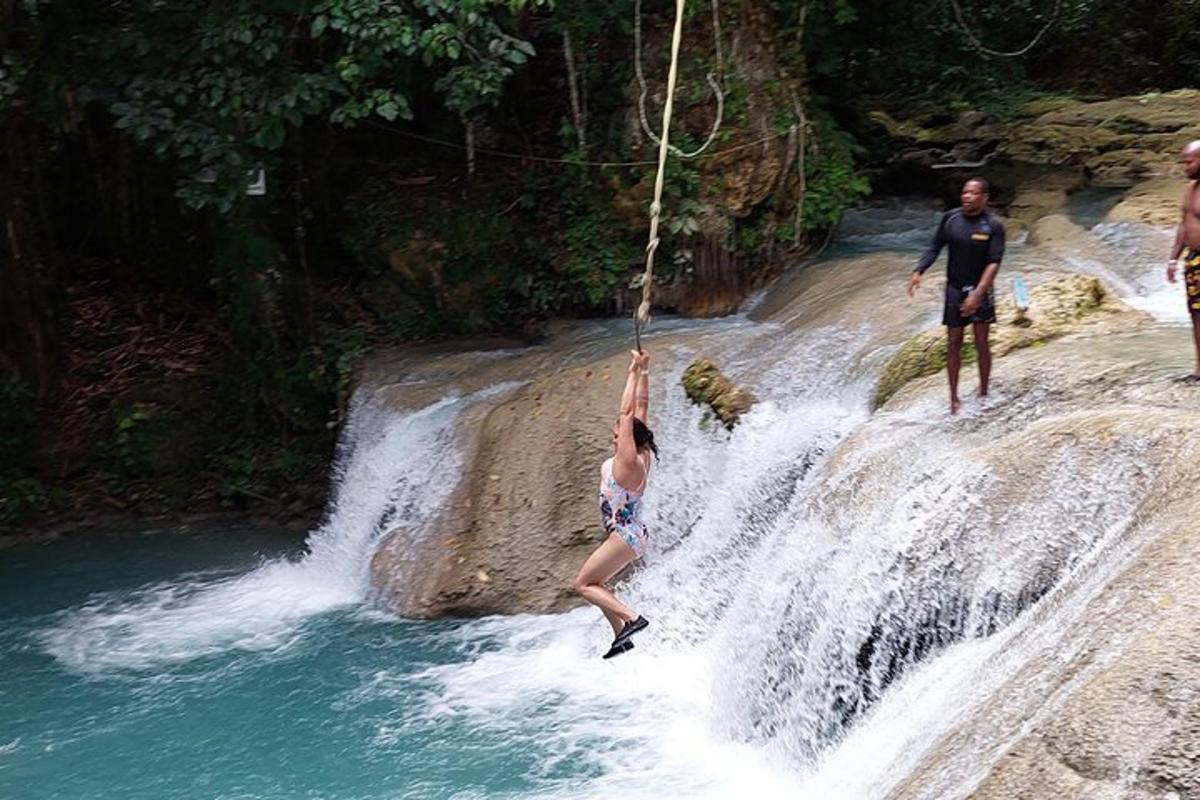 una persona è appesa a una corda sopra una cascata