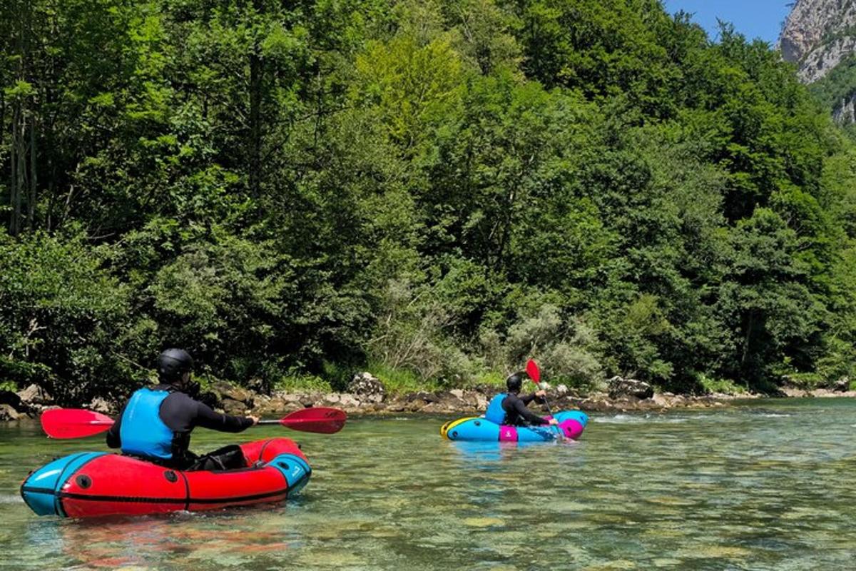Muž a dítě se projíždějí na nafukovacích člunech v řece