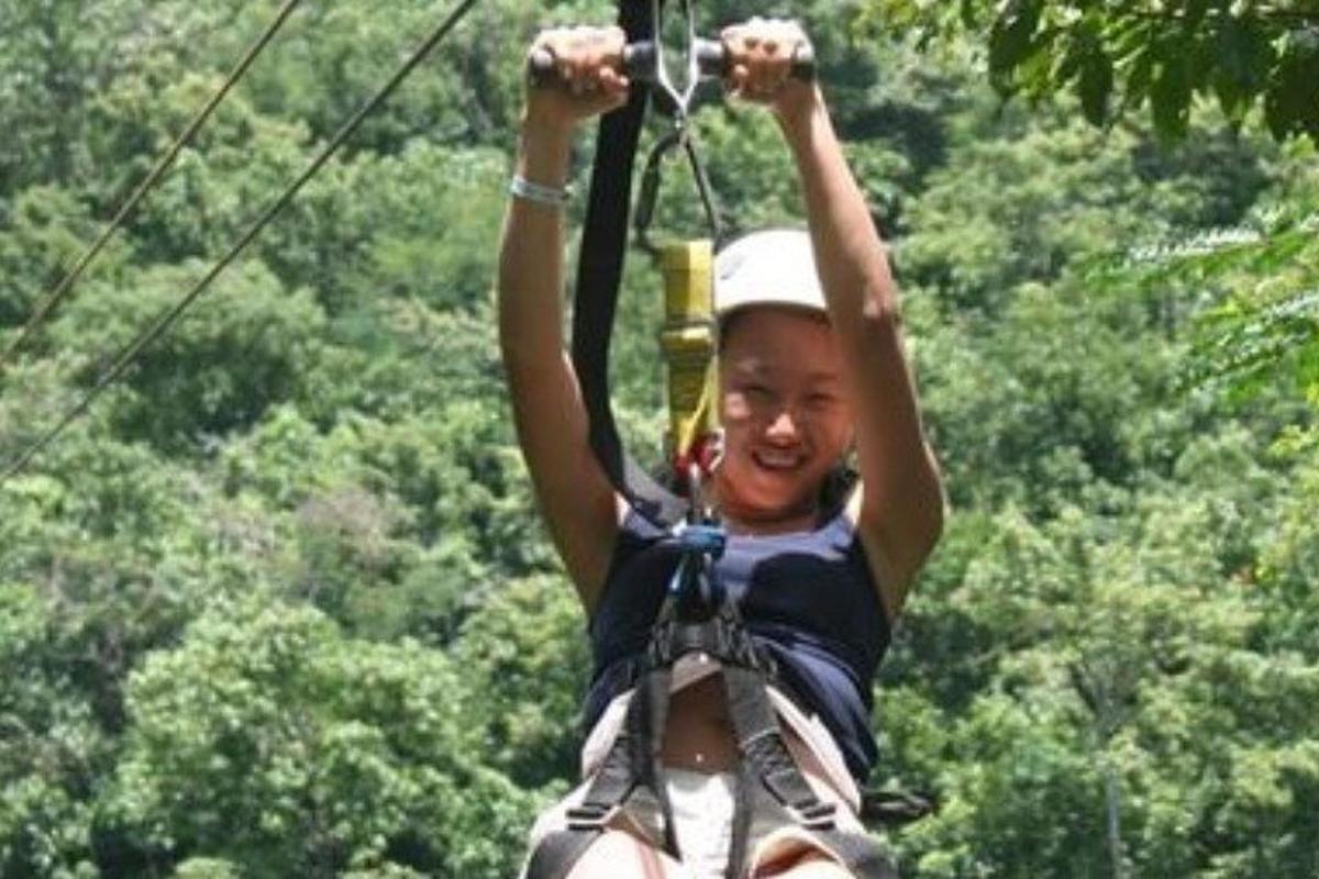 una ragazza su una teleferica tra gli alberi