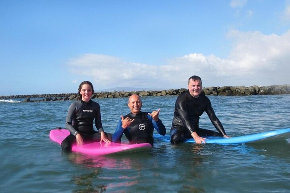 three people sitting on surfboards in the water
