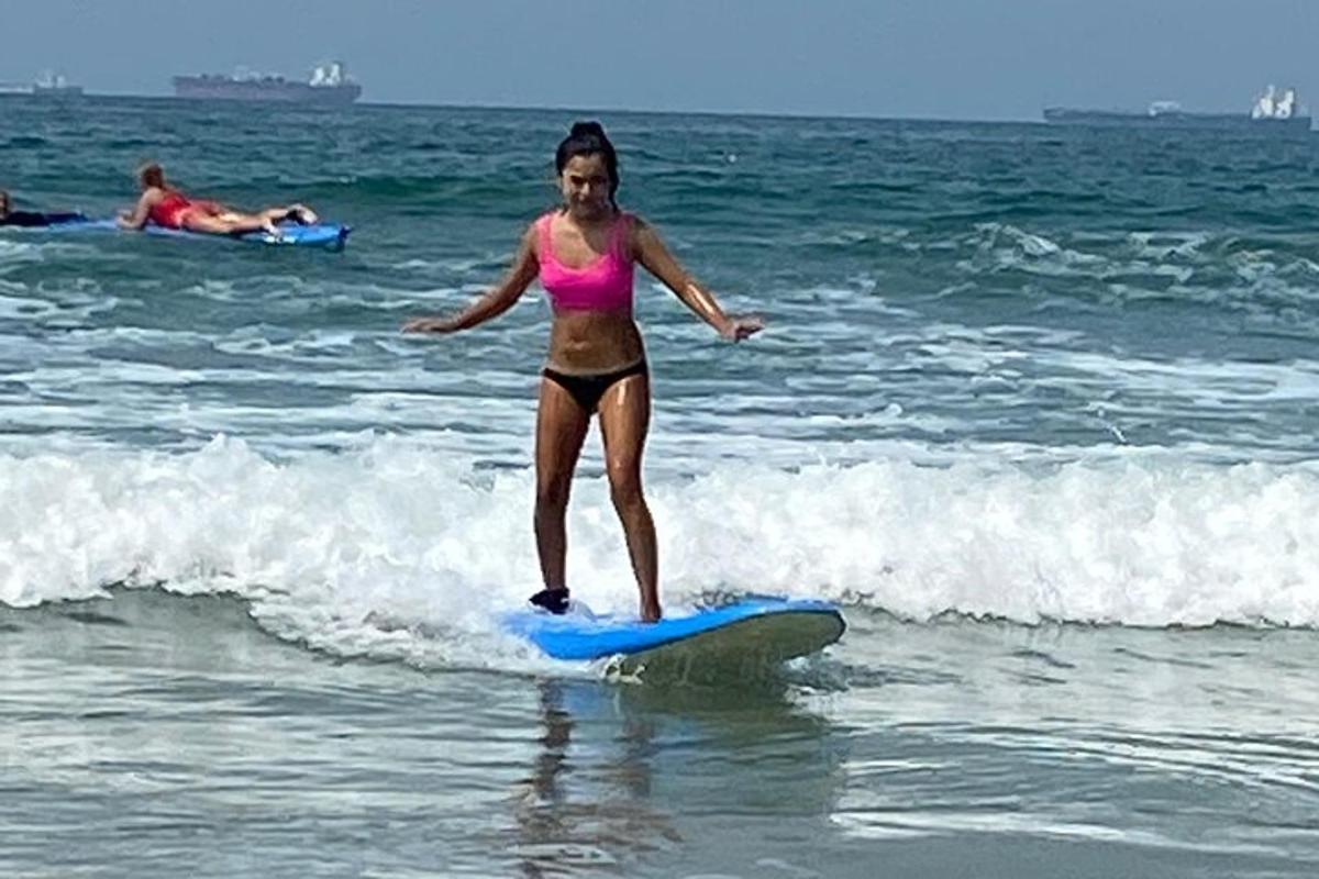 a girl in a bikini riding a surfboard in the ocean
