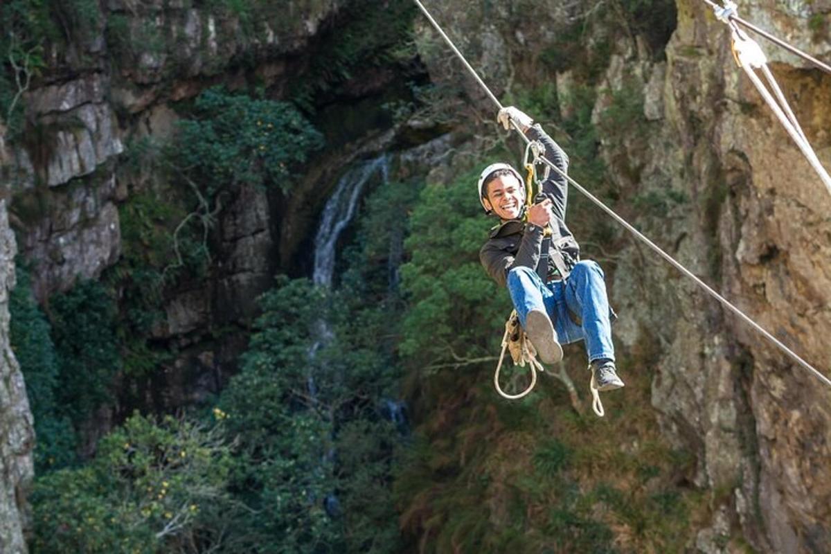 una persona su una teleferica di fronte a una cascata