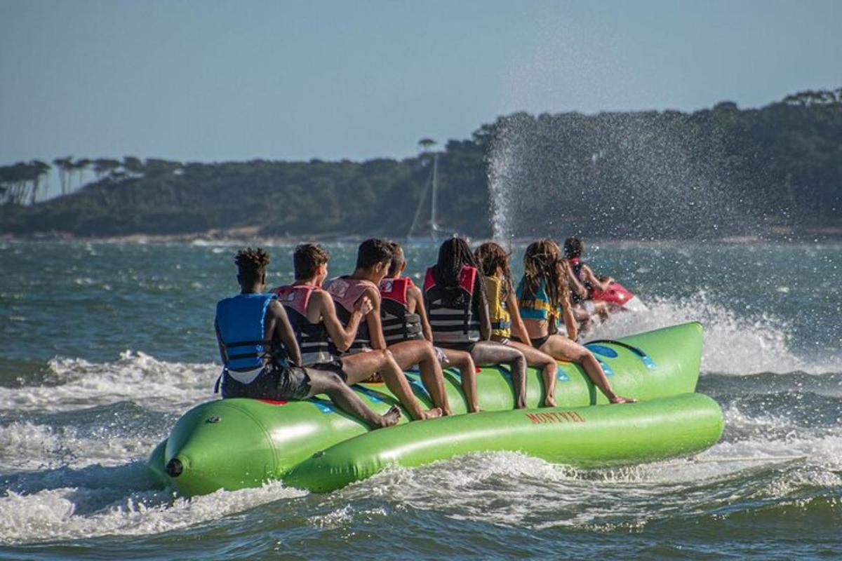 a group of people riding on a green raft in the water