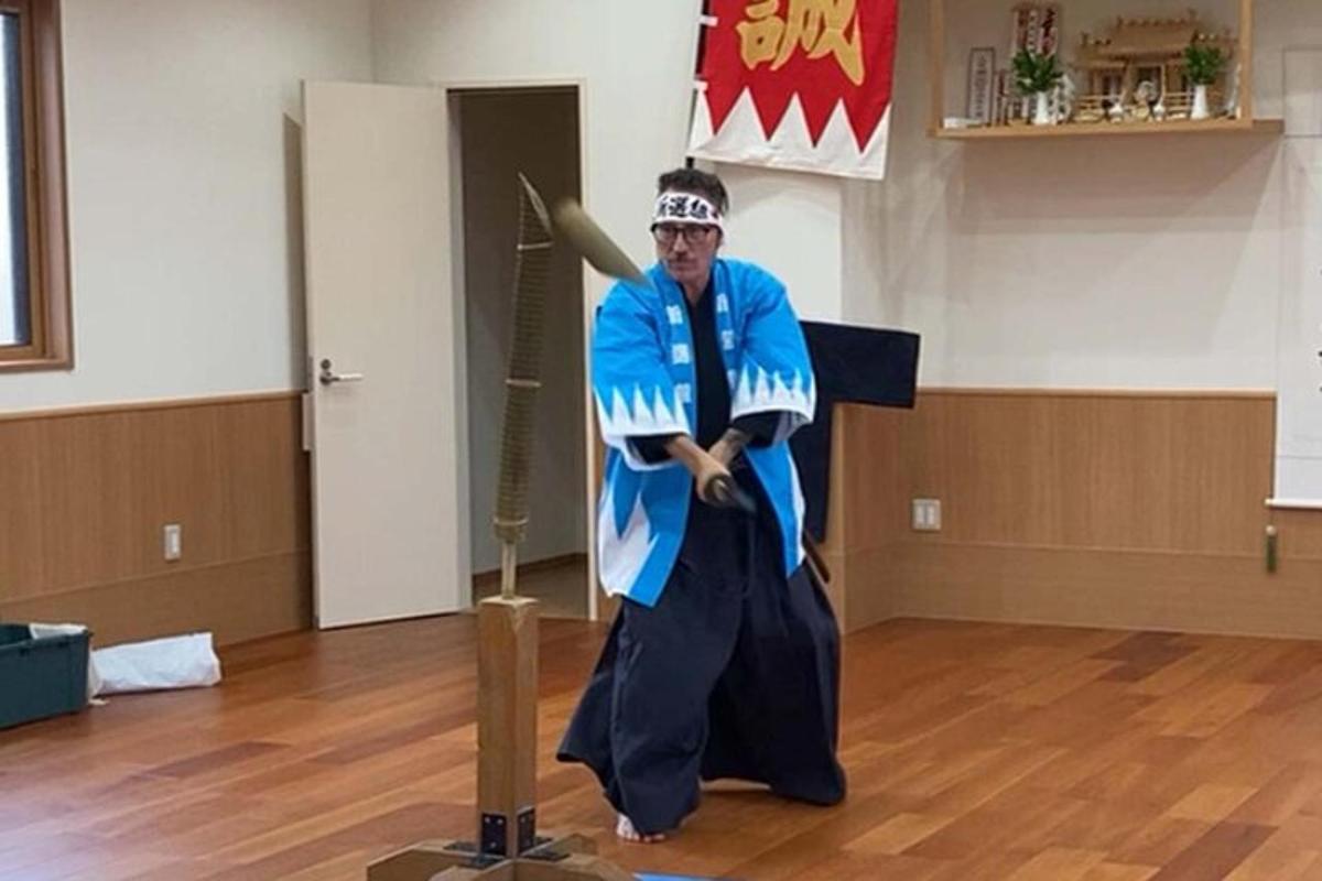 un uomo in costume con una spada in una stanza