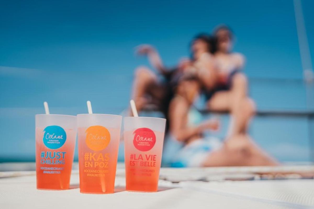 drei Plastikbecher auf einem Tisch in der Nähe eines Swimmingpools